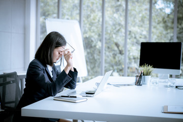 Asian business woman headache stressed because of work mistake problems about profit losses to be...