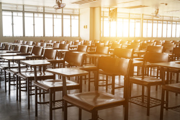 Empty classroom with vintage tone wooden chairs. Back to school concept.