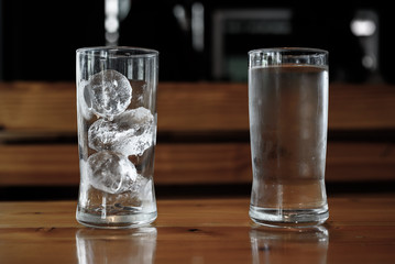 The glass of ice and water on the table