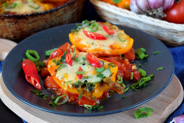 Two halves of stuffed bell peppers on a dark plate