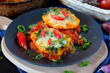 Two halves of stuffed bell peppers on a dark plate