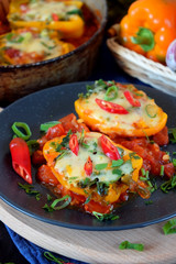 Two halves of stuffed bell peppers on a dark plate
