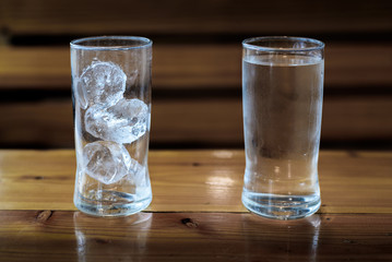 The glass of water and ice on the tabel