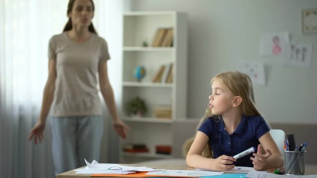 Angry mother criticising and screaming at little daughter, family problems