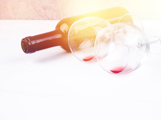 Wine glass and Bottle on a wooden background, bottle of red wine and glasses lying on an old wooden table. Close up view, focus on the bottle of red wine