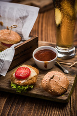 Mini burgers on wooden background