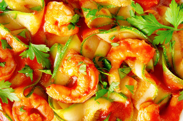shrimps with zucchini under tomato sauce decorated with parsley