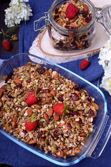 Granola made of oatmeal flakes, nuts and seeds decorated with fresh raspberries