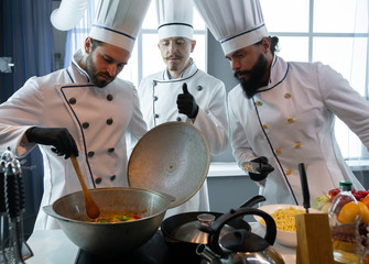 Three chefs near the pan
