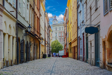 An empty street between tall houses in an old European city with an empty store sign