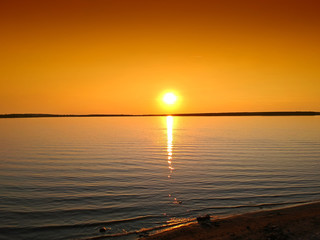  Beautiful sunset on German lakes. The lakes lie near Bohemia and Poland under the Berlin. The sunset has beautiful yellow and orange colors and you can see the waves of the lake and the sandy beach.