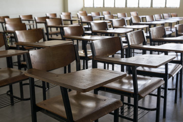 Fototapeta premium Empty classroom with vintage tone wooden chairs. Back to school concept.