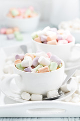Fototapeta na wymiar cocoa with colorful marshmallow in white cups, vertical closeup