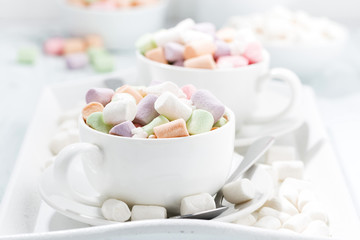 cocoa with colorful marshmallow in white cups, closeup