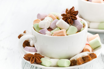 cocoa with colorful marshmallows in cup and Christmas cookies on white table