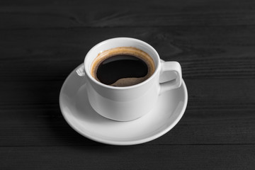 Obraz na płótnie Canvas Black coffee in white cup on black wood background