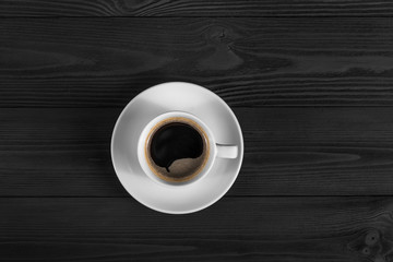 Black coffee in white cup on black wood background