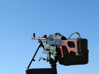 Kalashnikov machine gun mounted on the car, isolated on a clear blue sky. Russian legendary weapon, PK machinegun, caliber 7.62 mm