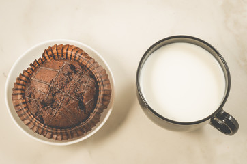 chocolate muffin and milk/chocolate muffin and milk on a white marble background. Top view