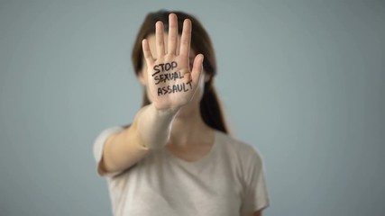 Bruised woman with stop sexual assault sign on hand, discrimination prevention