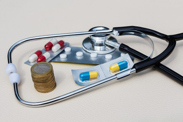 Stéthoscope, argent et plaquettes de médicaments
