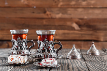 Fototapeta na wymiar Fragrant Turkish tea and Turkish sweets in national dishes