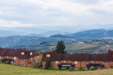 Fototapeta na wymiar Nice brick house with mountains in the background in Tineo, Asturias, Spain