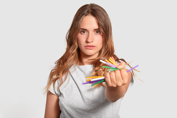 Isolated shot of attractive serious girl bans using plastic tubes, refuses of pollution, has...