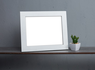 Blank white picture frame on gray wall