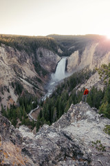 Traveler man watching over Lower Yosemite falls at the sunset
