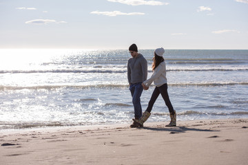 Loving young couple on a beach at autumn sunny day