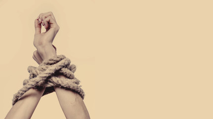 Bound woman's hands as symbol of desire for freedom (struggle, tension, independence, pain concept)