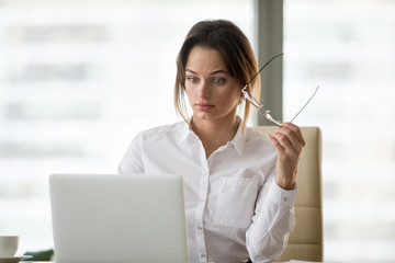 Shocked surprised businesswoman amazed by reading unbelievable online breaking news on laptop,...