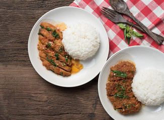 Thai spicy food,Stir-fried chicken and pork whit basil with rice on table wood