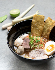 Thai spicy noodle,Thai noodle tom yum with pork,egg and meat ball on grey concrete