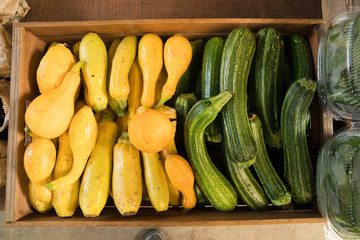 Assorted squash and zucchini in a crate ready for sale at a market stand