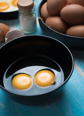 Cracked eggs in bowl and egg shells for cooking