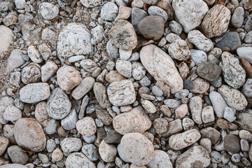 Pebbles as texture and background for design. Abstract background made with small stones. Mountain rock floor.
