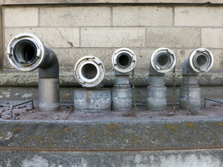 Rohre und Anschlüsse für Wasserschläuche ragen aus einem Betonboden