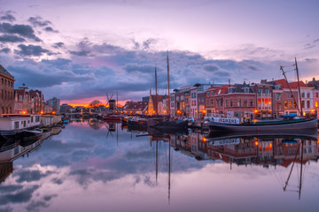 View of the canals of the city of Leiden with hoses, ships and boats at sunset. View of city...