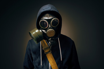 businessman wearing gas mask in the dark