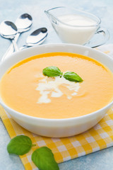 Pumpkin soup with basil on blue background