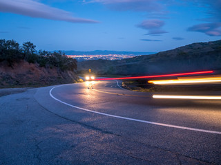 Cars Tail Lights Trails On a Downhill Road With Silicon Valley in the Background