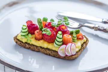 Danish smorrebrod with gravlax and omelet on rye bread