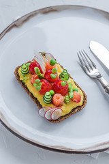 Danish smorrebrod with gravlax and omelet on rye bread