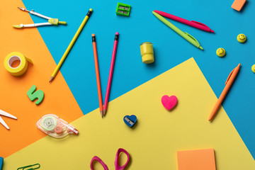 School supplies on a multi-colored background
