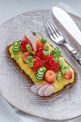 Rye sandwich with salmon and scramble egg, green peas and cucumber.