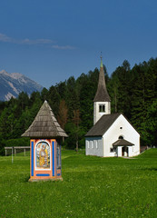 Fototapeta na wymiar Wayside shrine and chapel in Alpine meadow