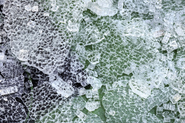 Broken glass pieces on an asphalt surface