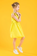 Girl posing on yellow background.